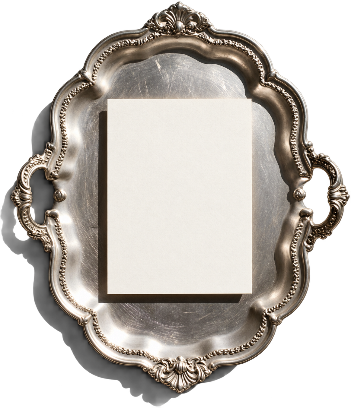 A sheet of ivory paper resting on an ornate silver plate